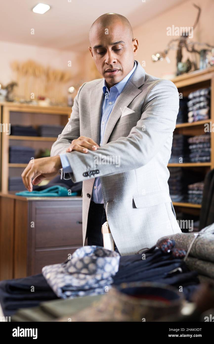Homme choisissant la veste de costume dans le magasin de vêtements Photo  Stock - Alamy