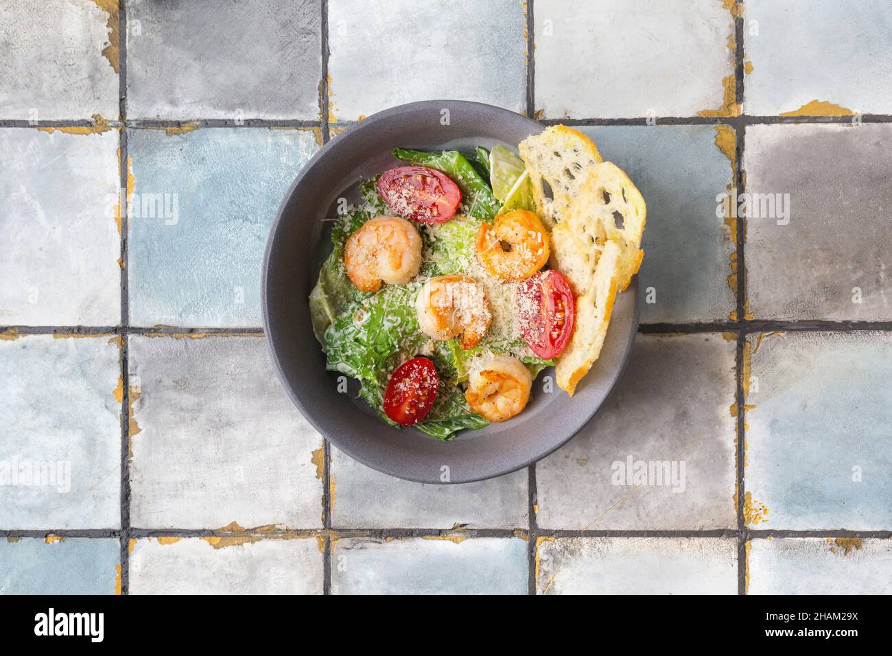 Salade César aux crevettes et au parmesan sur fond de carreaux Banque D'Images