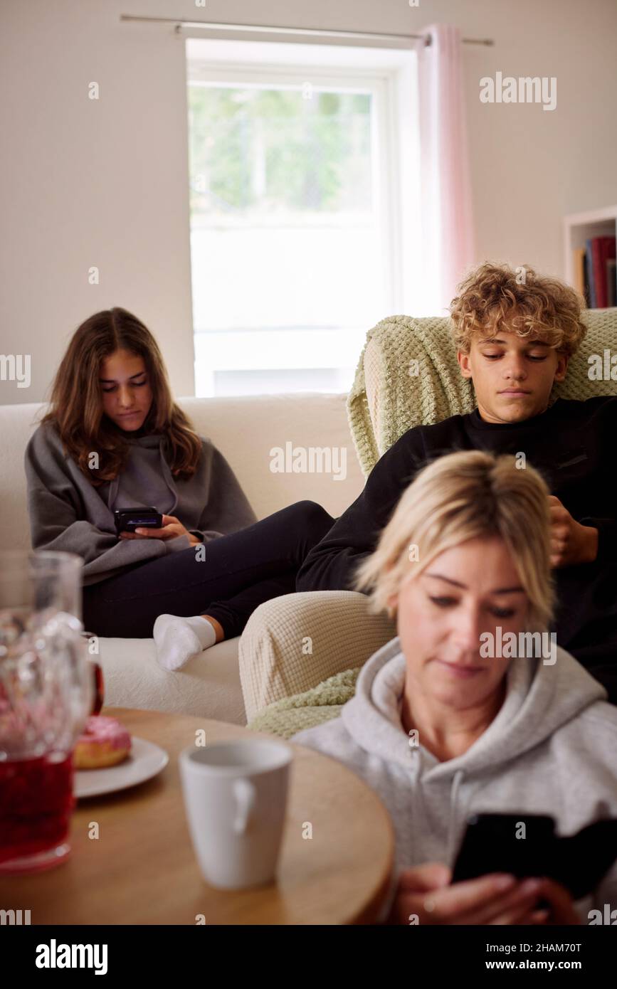 Famille utilisant un smartphone dans le salon Banque D'Images
