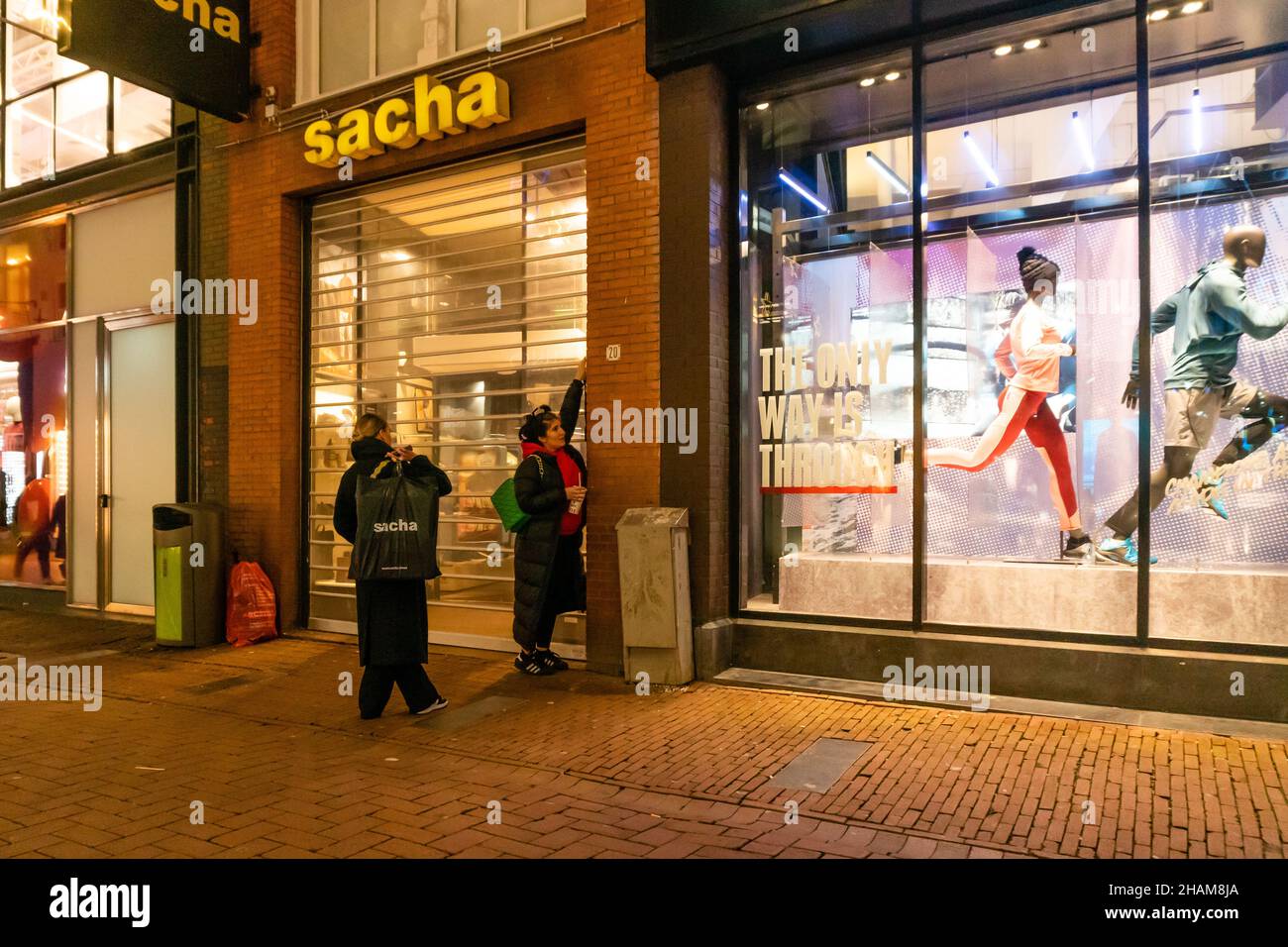 Amsterdam, pays-Bas, 13-12-2021. Deux assistants ferment un magasin à 17:22 dans la Kalverstraat, l'une des rues commerçantes les plus fréquentées d'Amsterdam.Le Cabinet néerlandais va probablement prolonger le « verrouillage de soirée », ce qui signifie que la plupart des entreprises sont fermées à partir de 5 heures. Les mesures actuellement en vigueur jusqu'en décembre 19th resteront probablement en vigueur jusqu'au début de janvier 2022.Le mardi soir déc.14, le premier ministre sortant Mark Rutte et le ministre des soins de santé Hugo de Jonge donneront une conférence de presse.Credit: Steppeland/Alay Live News Banque D'Images