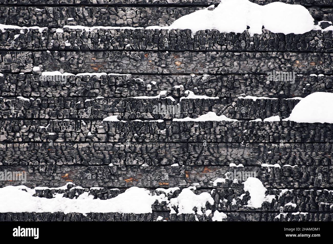 Cadre plein texturé noir avec une pile de bureaux en bois charrés de neige et de fissures Banque D'Images