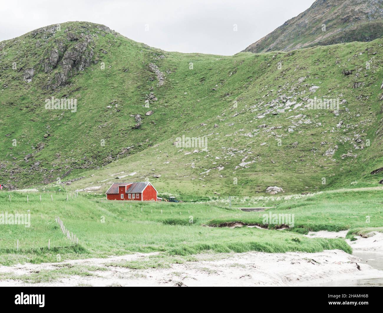 Maison de ferme norvégienne traditionnelle en bois rouge entourée de montagnes.Séparer la maison.Paysage minimal Banque D'Images