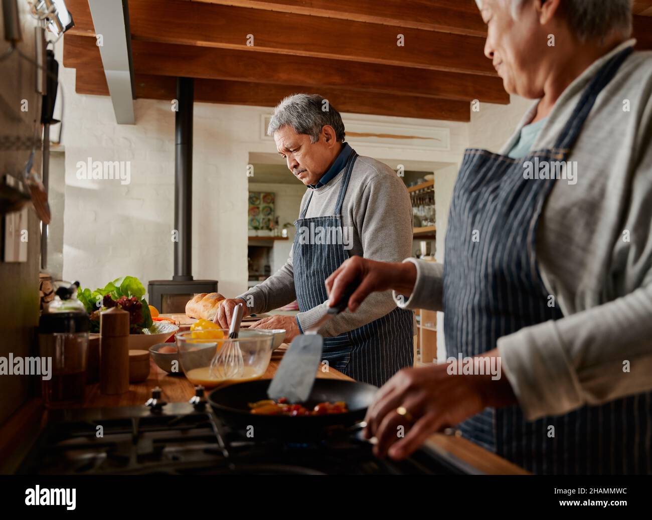 Un couple multiethnique prépare le petit-déjeuner dans une cuisine moderne.Heureusement à la retraite. Banque D'Images
