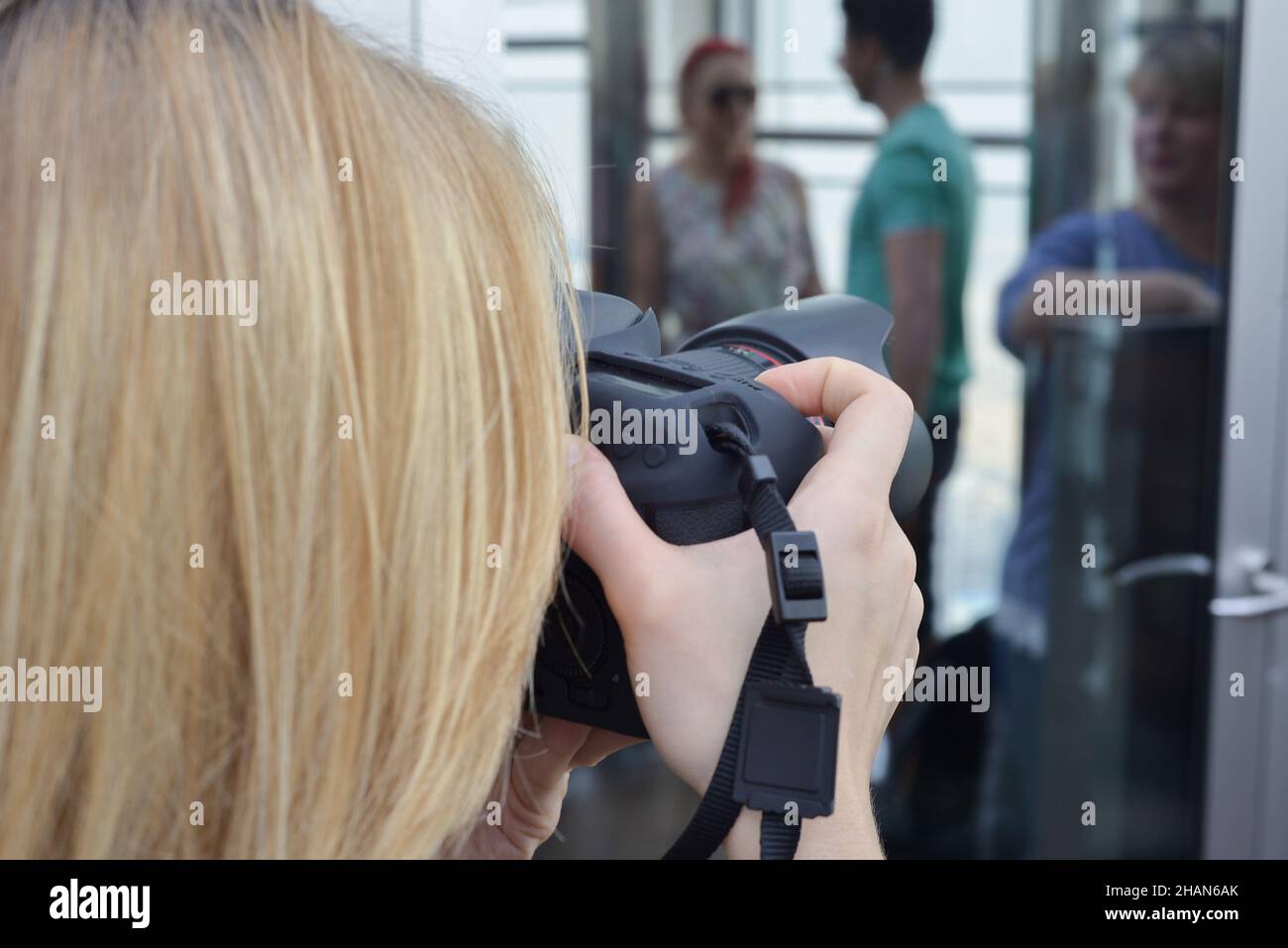 Jeune femme photographe prenant des photos à l'extérieur sur un appareil photo numérique pendant la journée Banque D'Images
