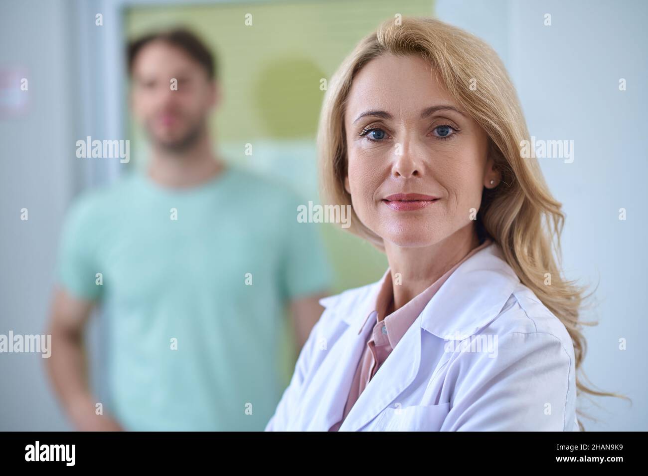 Femme en manteau blanc regardant l'appareil photo Banque D'Images