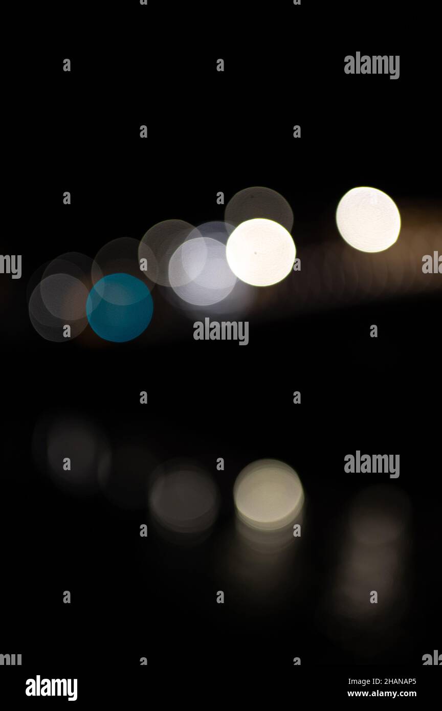 Lumières colorées floues sur le pont avec réflexions dans l'eau Banque D'Images