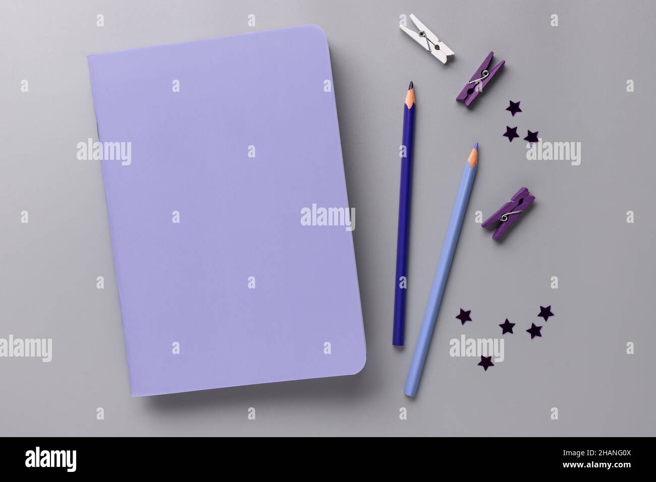 bureau sur un bureau gris avec carnet blanc violet, crayons Banque D'Images