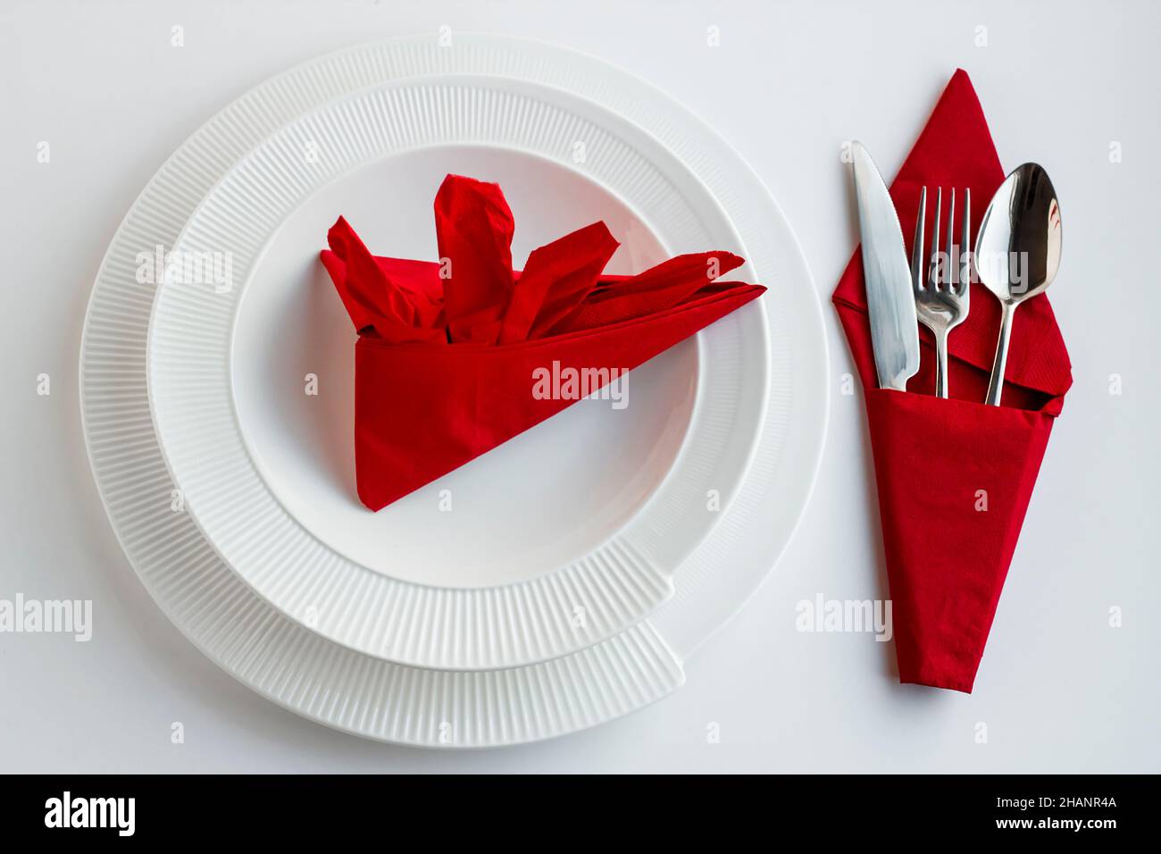 Mise en place de la table de Noël ou du nouvel an avec des serviettes de table rouges pliées élégantes et un ensemble de couverts Banque D'Images