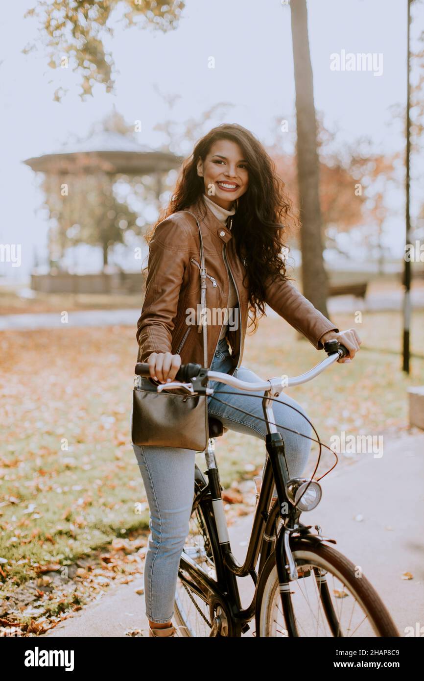 Jolie jeune femme à vélo le jour de l'automne Banque D'Images
