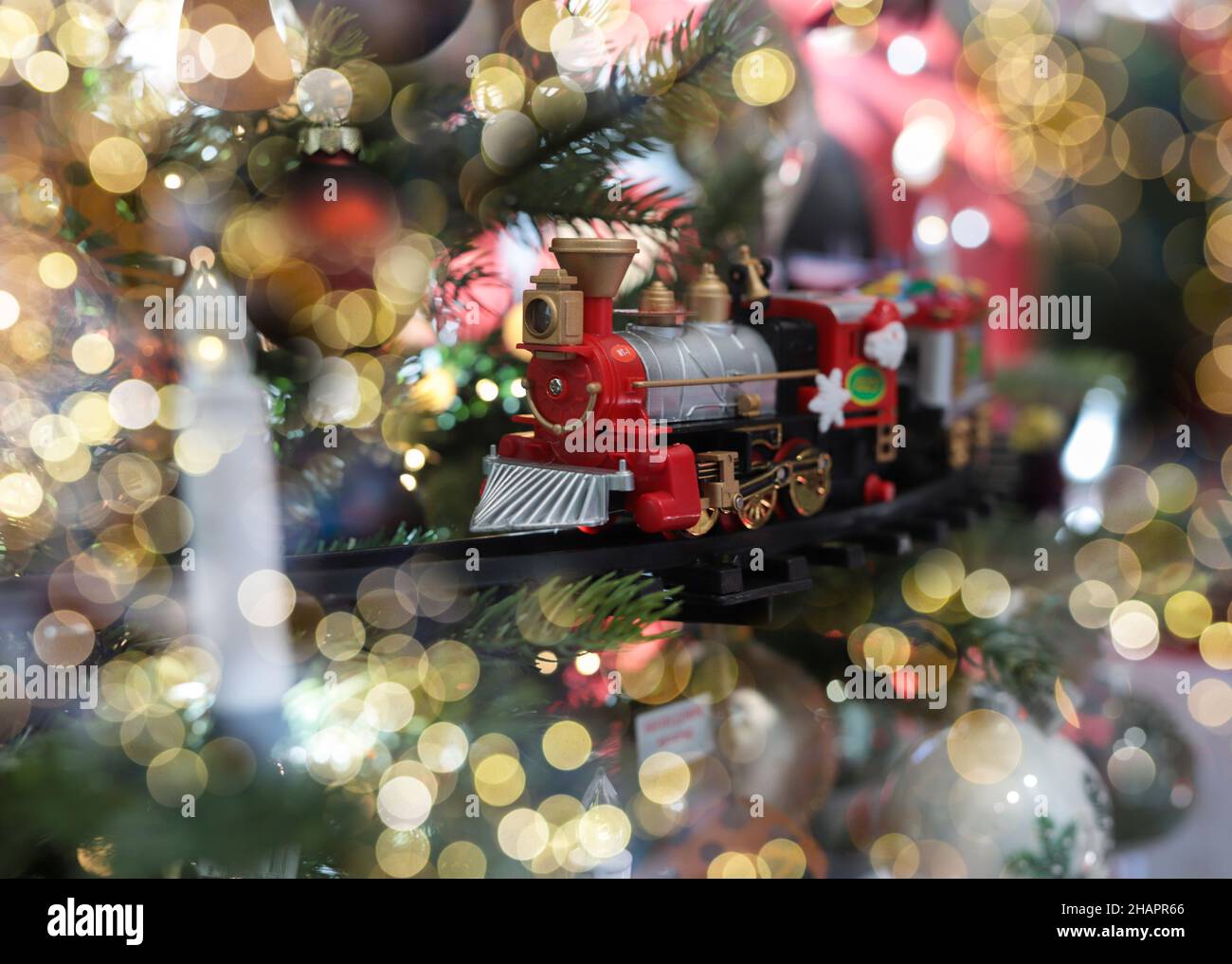 Minsk, Bélarus - octobre 28 2021 jouet de train comme ornement sur l'arbre de Noël avec lumières floues. Banque D'Images