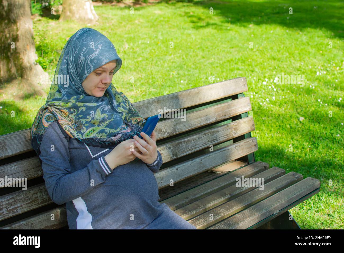 Femme enceinte musulmane prenant selfie dans le parc Banque D'Images