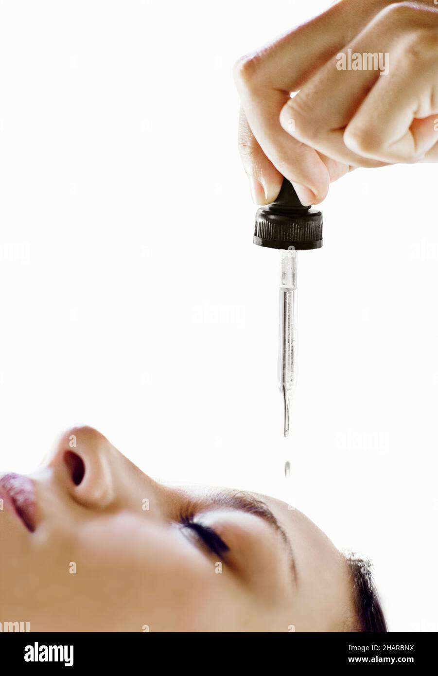 Les huiles essentielles sont appliquées sur le front d'une femme au début d'un massage indien de la tête, un traitement de 50 minutes traditionnellement connu sous le nom de Champsage. Banque D'Images