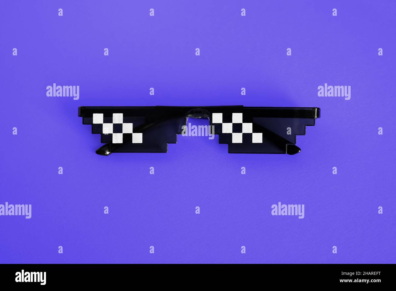 Lunettes de soleil en forme de boss pixélisées sur un nouveau fond bleu Pantone.Gangster, Black thoug Life meme verres .Style Pixel 8bit.Pantone 2022.Très Peri Banque D'Images