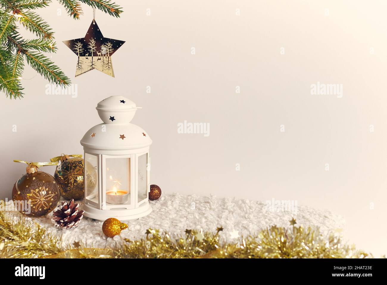 Fond de Noël, une épinette avec une étoile et une bougie, des boules pour la décoration et un cône sur fond blanc.Photo du nouvel an.Vue avant. Banque D'Images