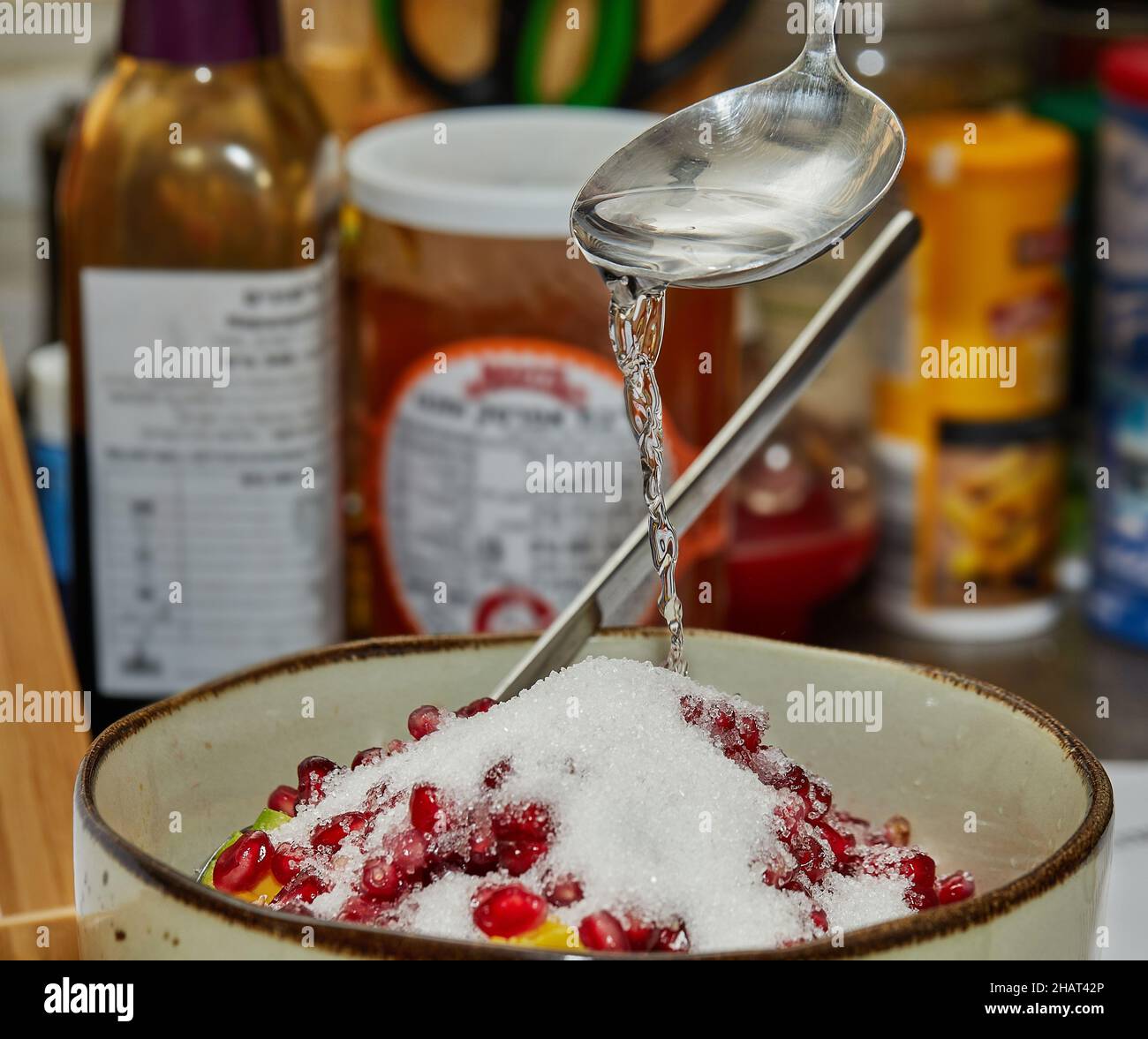Le chef ajoute du sirop à la salade de fruits à la maison dans la cuisine. Banque D'Images