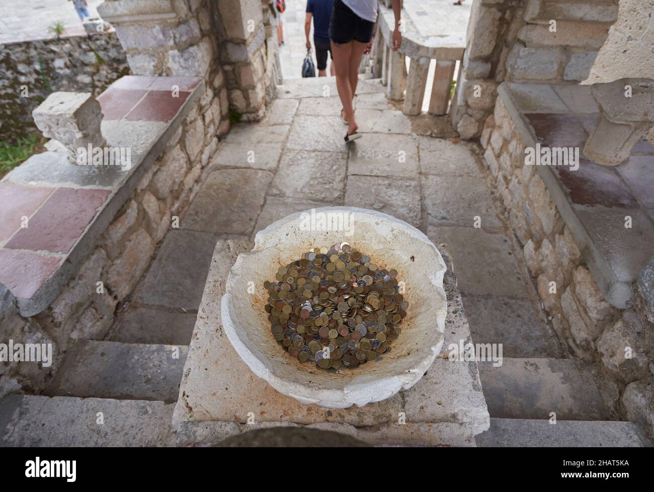 Les touristes laissent dans le bol de pierre des pièces de monnaie chanceux dans l'église à des souhaits. Banque D'Images