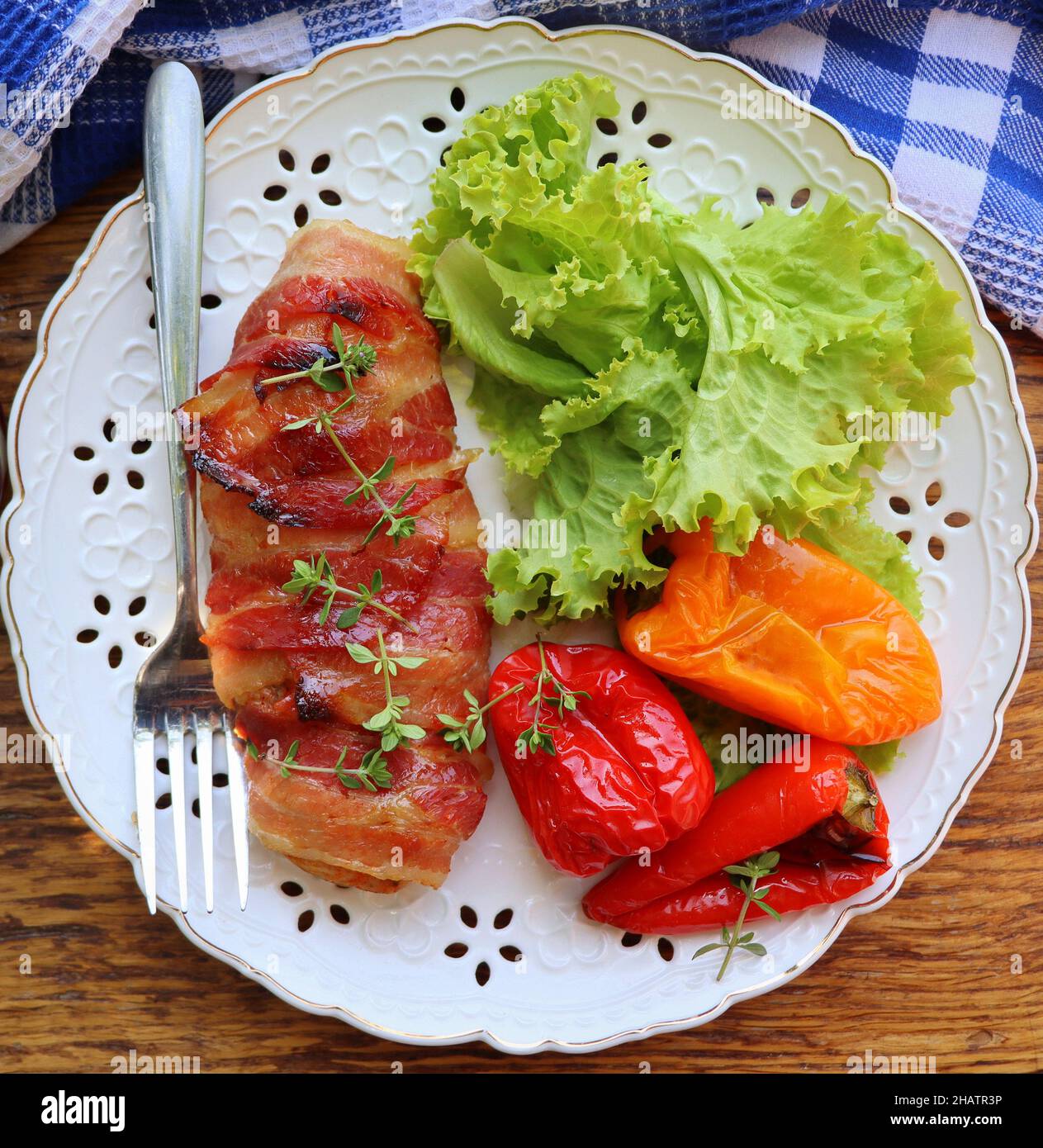 Arrière-plan du dîner.Blanc de poulet grillé enveloppé de bacon dans une poêle sur une table rustique en bois.Vue de dessus Banque D'Images