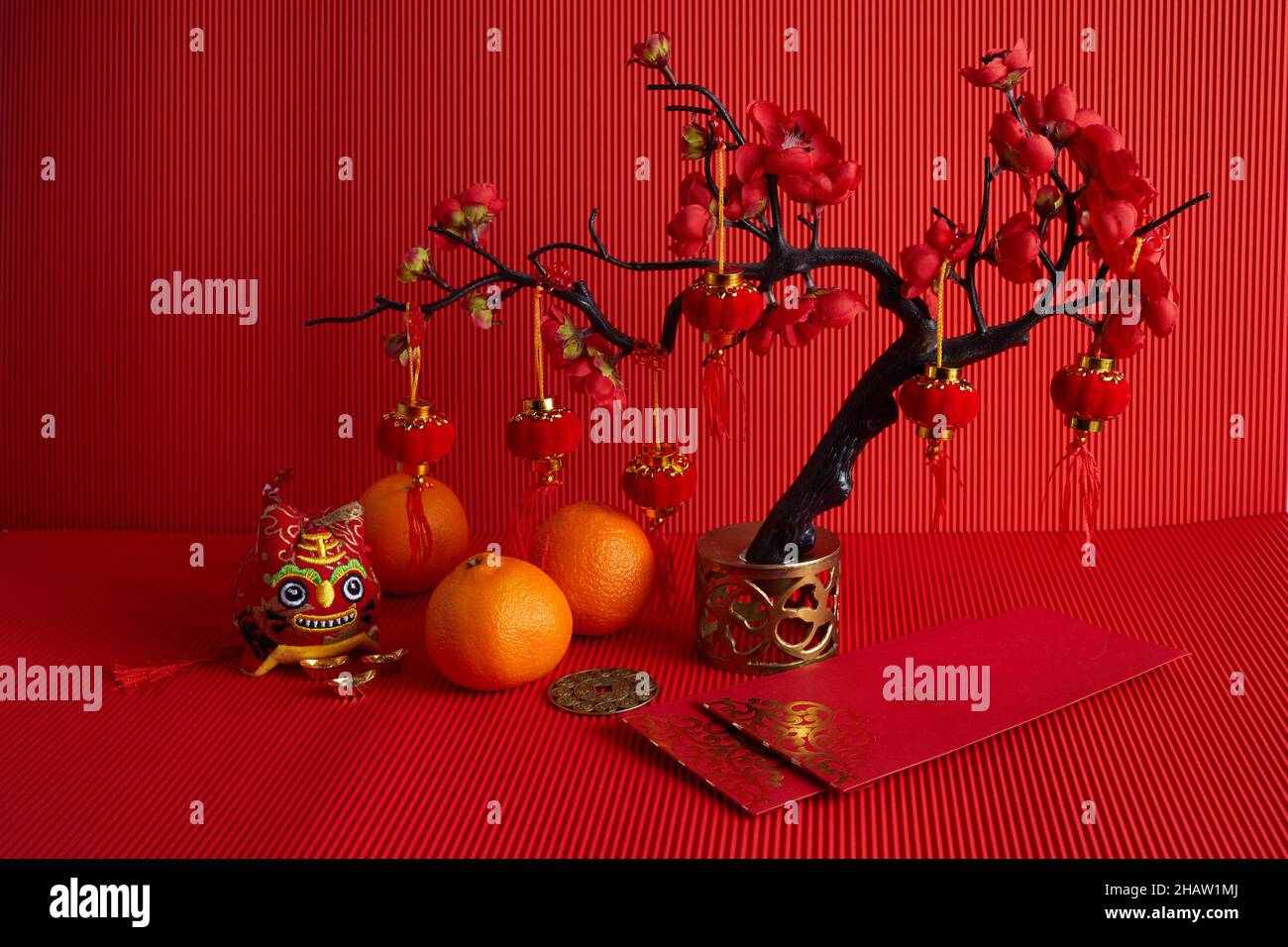 Décorations du festival du nouvel an chinois.Orange, feuille, paquet rouge, fleur de prune sur fond rouge. Banque D'Images