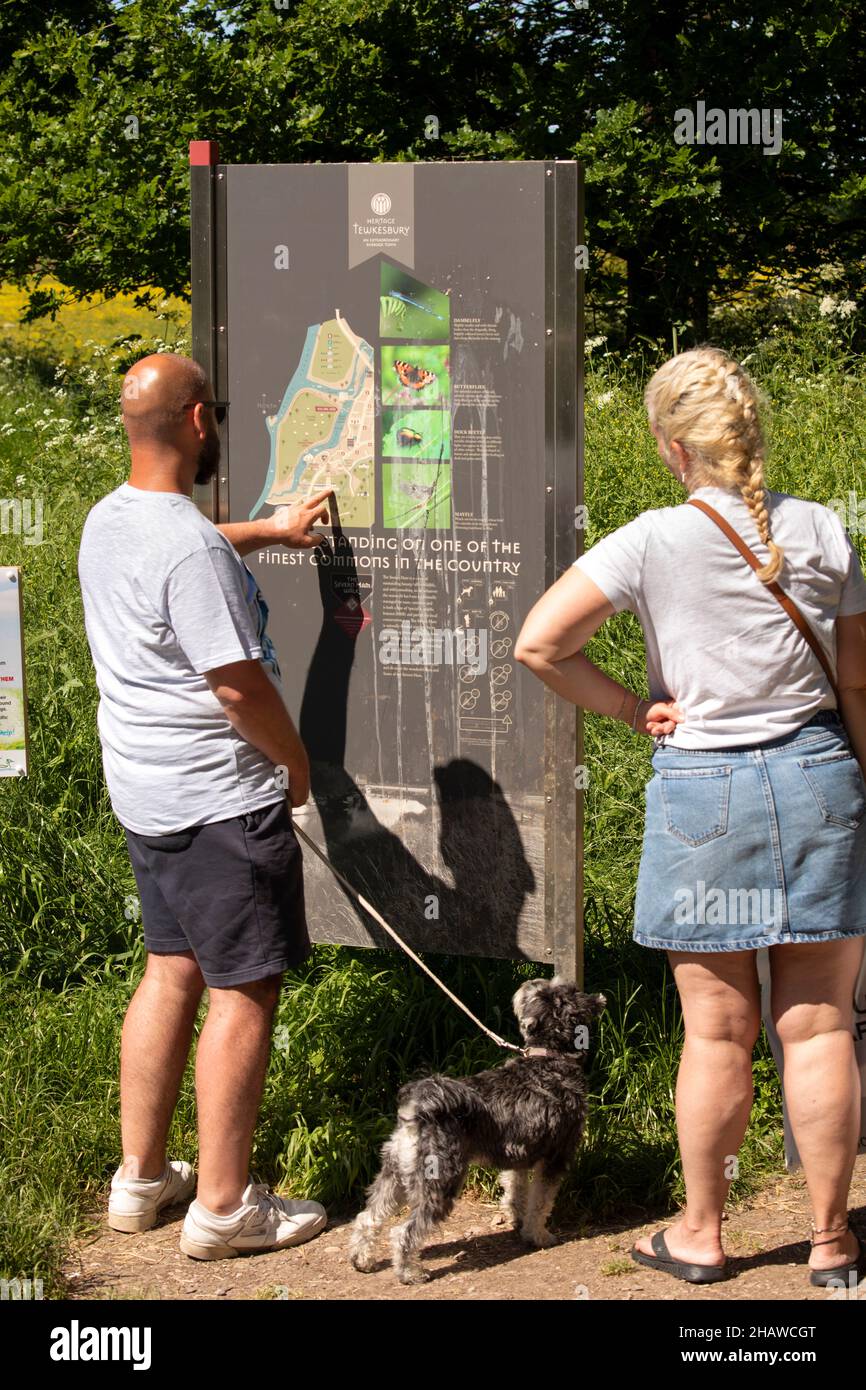 Royaume-Uni, Angleterre, Gloucestershire, Tewkesbury, Severn Ham,Visiteurs regardant le tableau d'information Severn Way, Banque D'Images