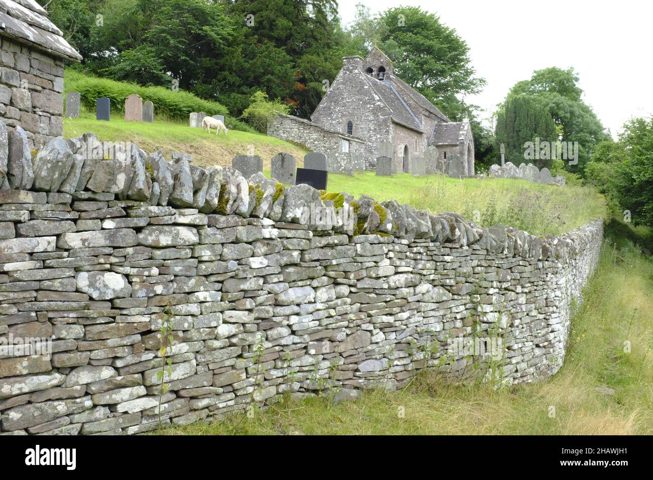 Eglise et cimetière de Saint-Issui derrière un mur de pierre sèche, Partrishow, Powys, pays de Galles Banque D'Images