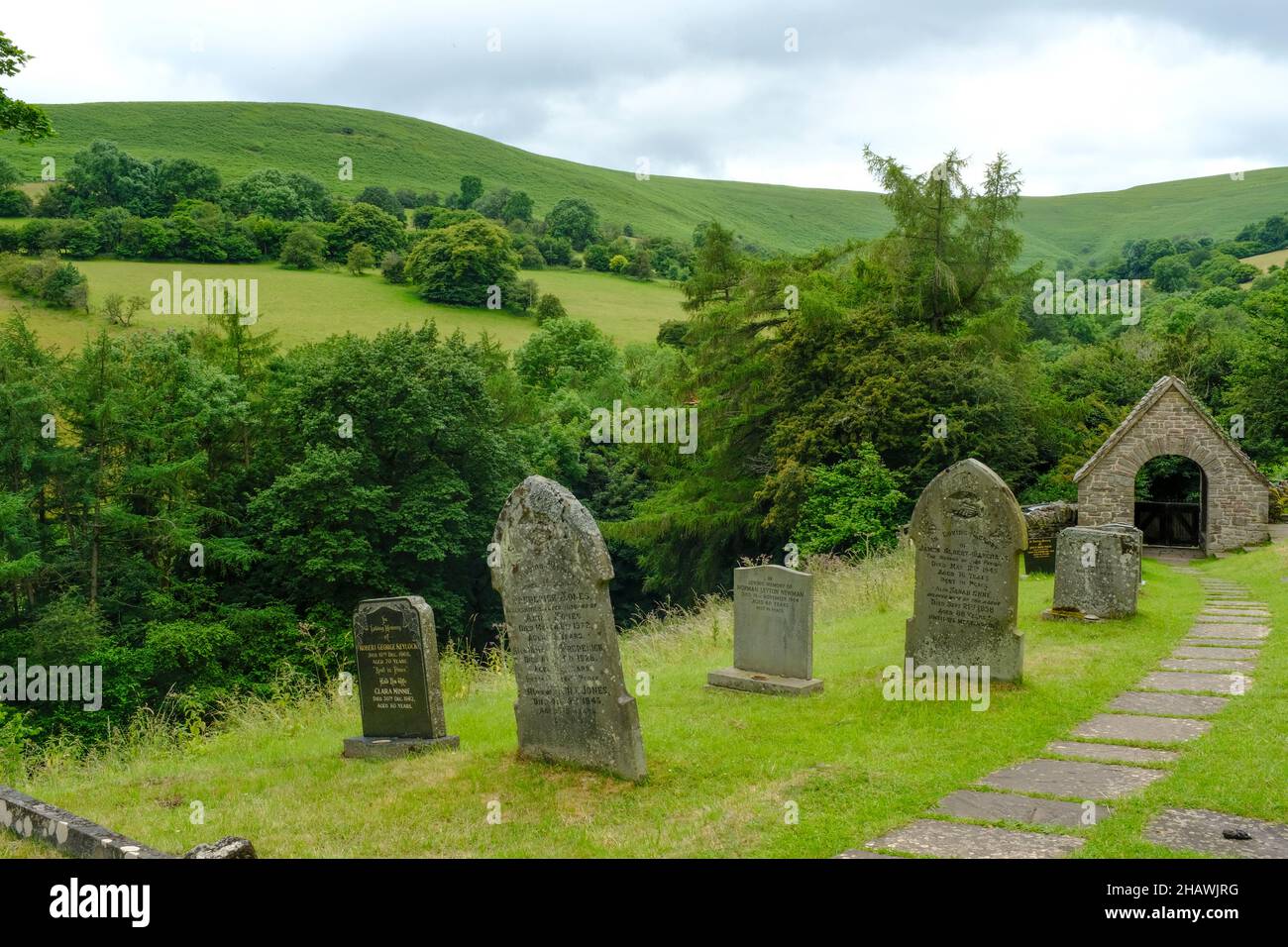 Cimetière de l'église Saint-Issui et porte couverte dans un paysage vallonné, Partrishow, Powys, pays de Galles, Royaume-Uni Banque D'Images