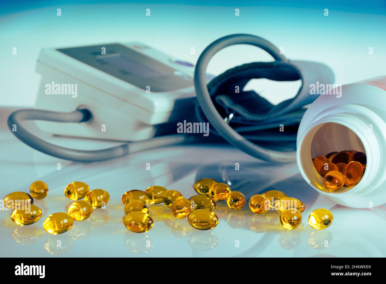 Capsules d'huile de poisson omega 3 pour la prévention contre l'hypertension, équipement pour mesurer la pression artérielle en arrière-plan, comprimés déversés de la bouteille Banque D'Images