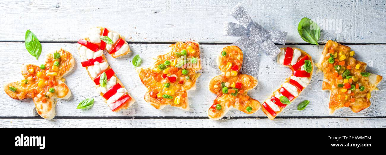 Pizza de Noël pour le dîner d'enfant, faite avec des emporte-pièces, sous forme de symboles traditionnels de Noël - Candy Cane, Gingerbread homme, arbre de Noël, drôle f Banque D'Images