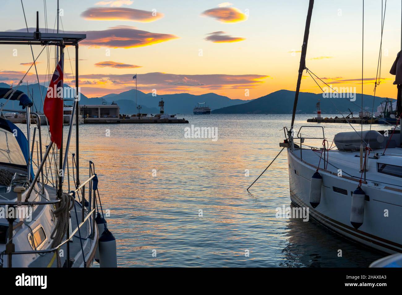 Bateaux de pêche, voiliers et yachts en début de soirée coucher de soleil le long du port et de la marina en face du village de pêche grec d'Aegina, Grèce, l'un des Banque D'Images