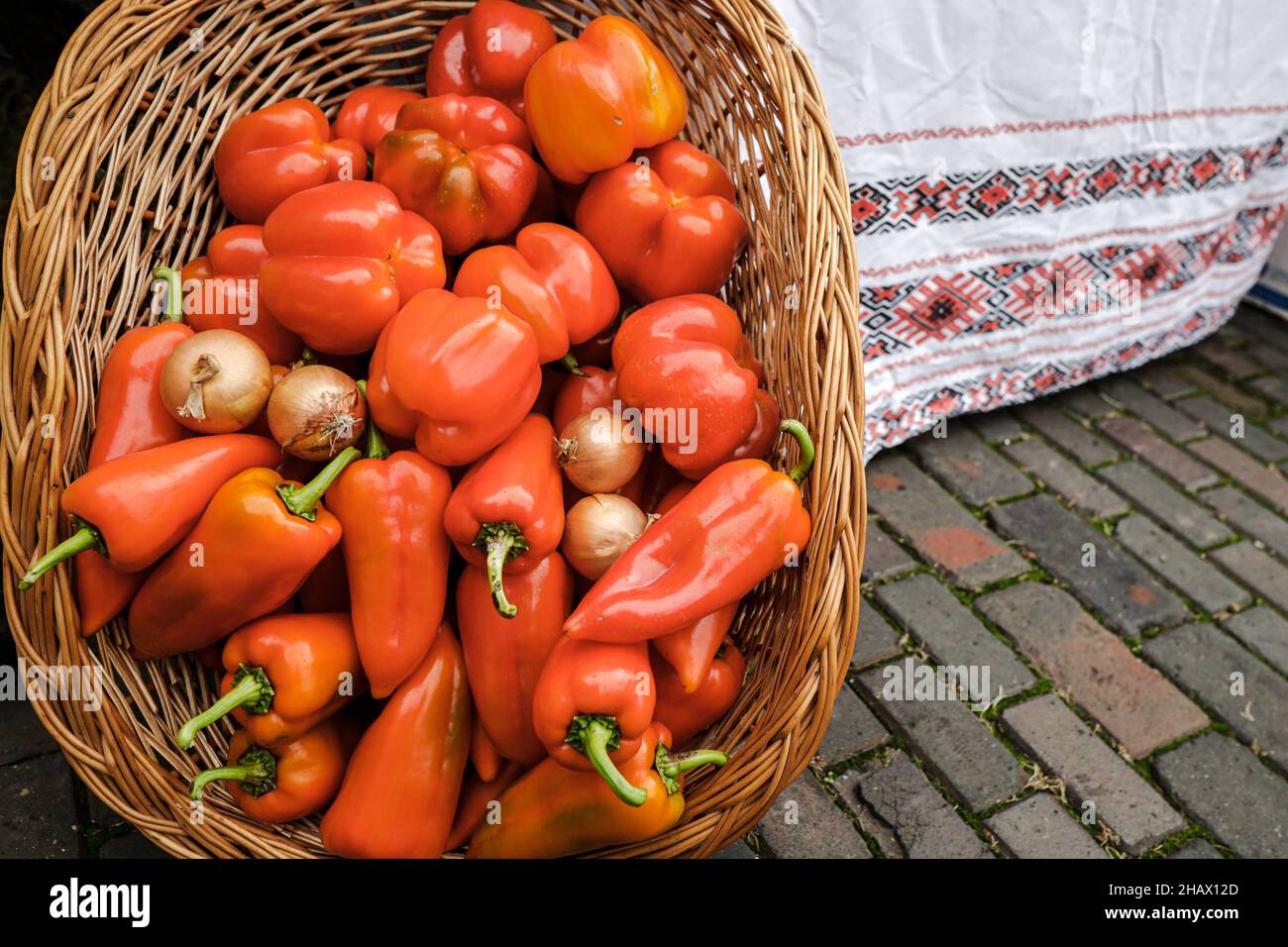 Image de faible profondeur de champ (mise au point sélective) avec un panier rempli de poivrons rouges frais biologiques à vendre dans un marché extérieur à Bucarest, Romani Banque D'Images