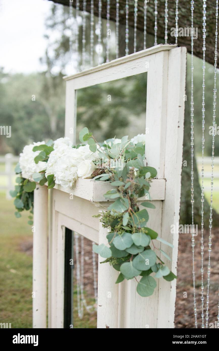 Cheminée avec miroir, roses blanches et feuilles vertes lors de la cérémonie de mariage des otdoes Banque D'Images Cheminée avec miroir, roses blanches et feuilles vertes lors de la cérémonie de mariage des otdoes Banque D'Images