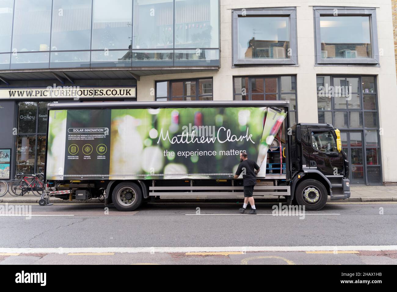 Le conducteur ouvre le panneau latéral en toile du camion de livraison Matthew Clark London Greenwich England Banque D'Images