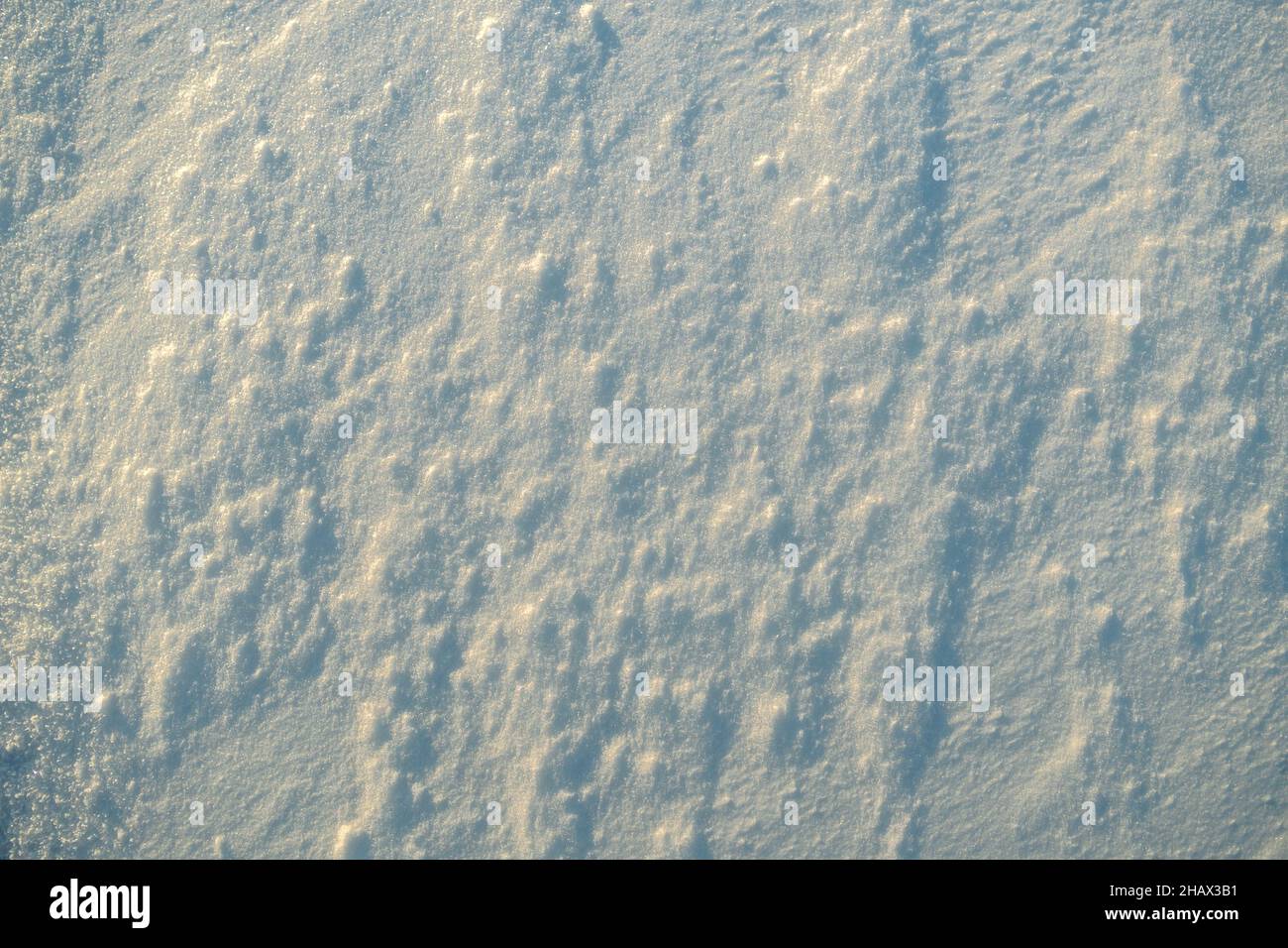 Texture inégale de la neige dans la lumière du coucher du soleil. Banque D'Images