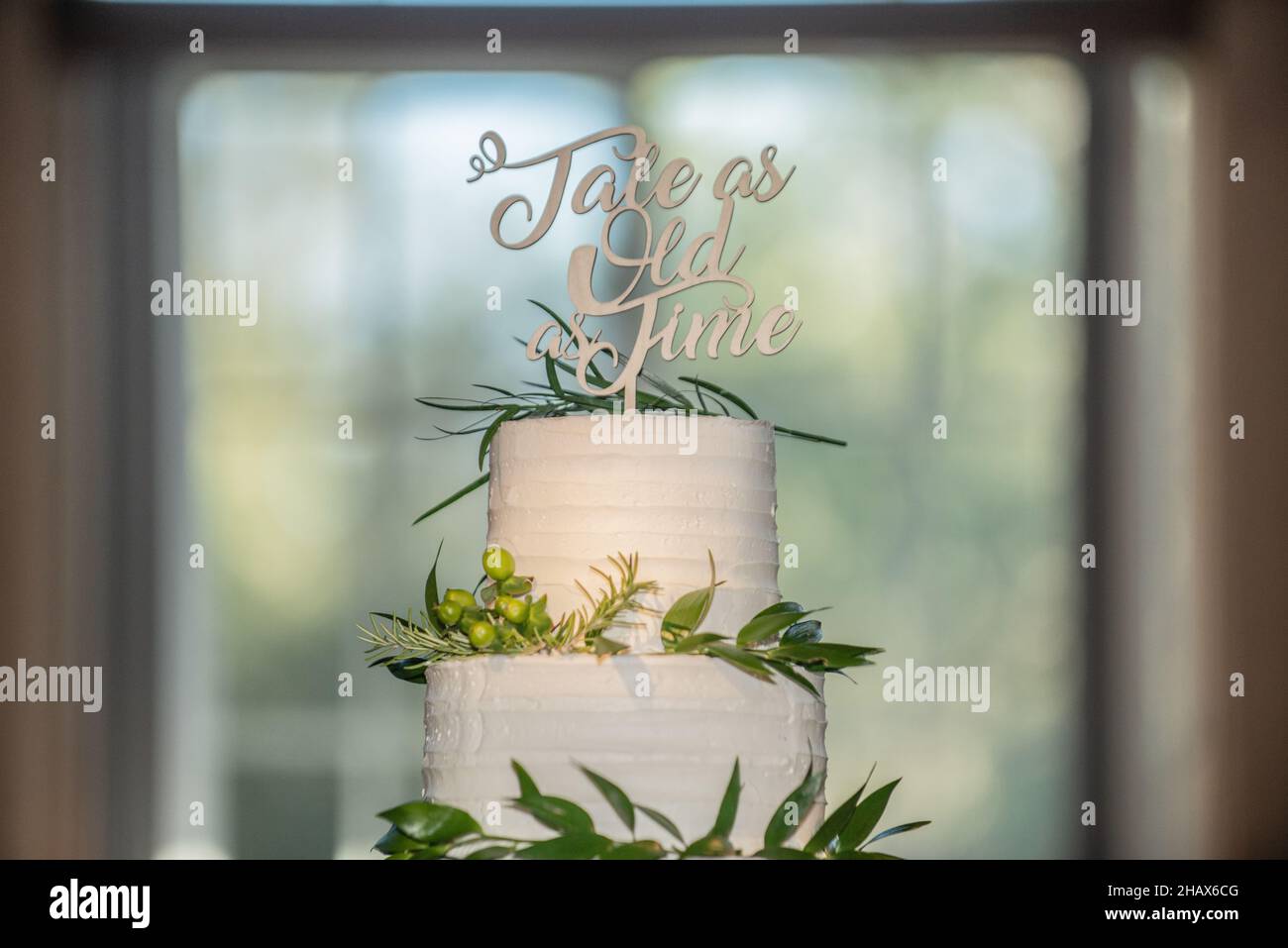 Gâteau de mariage blanc Beautiful à trois niveaux avec conte aussi ancien que le gâteau de temps topper Banque D'Images