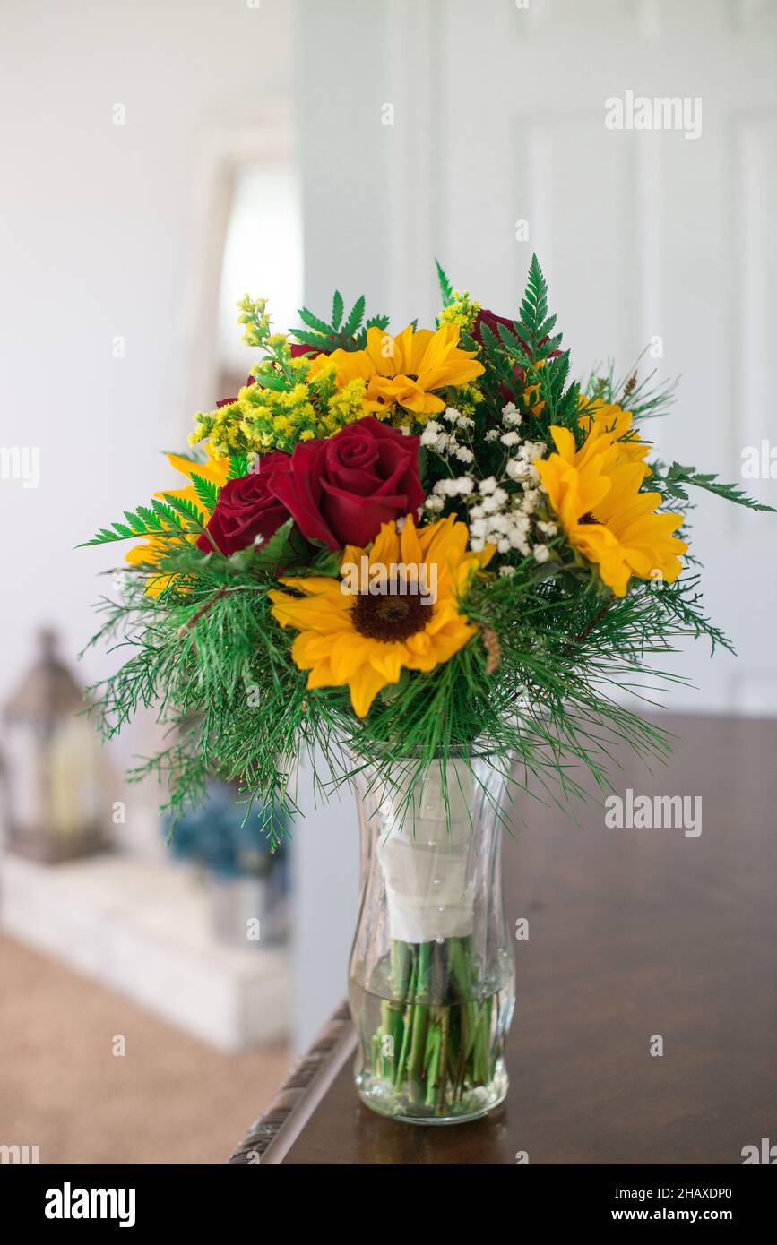 Bouquets de mariée avec fleurs de tournesol et roses rouges sur table en bois Banque D'Images