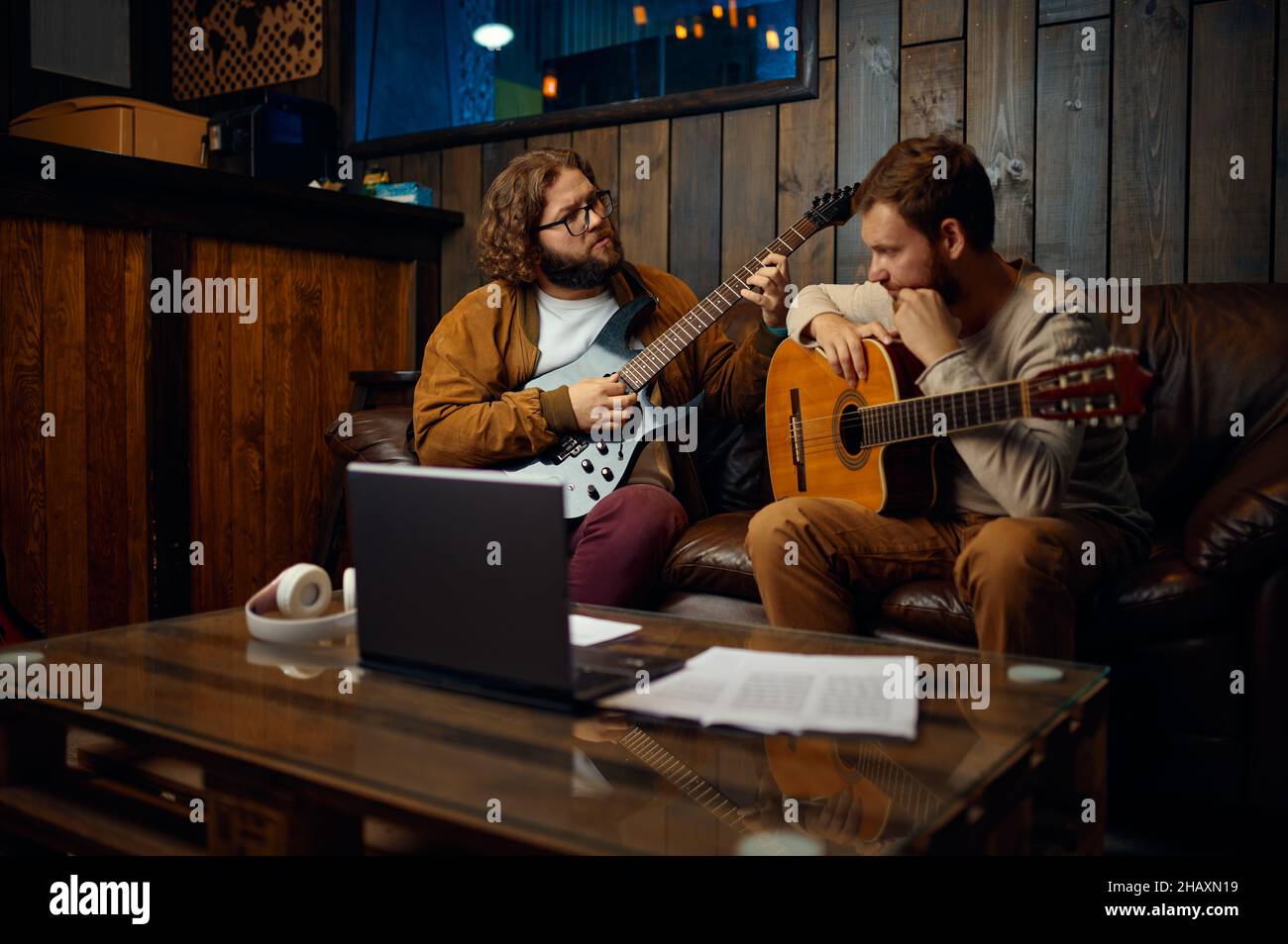 Un jeune homme écoute tout en jouant de la musique avec un guitariste Banque D'Images