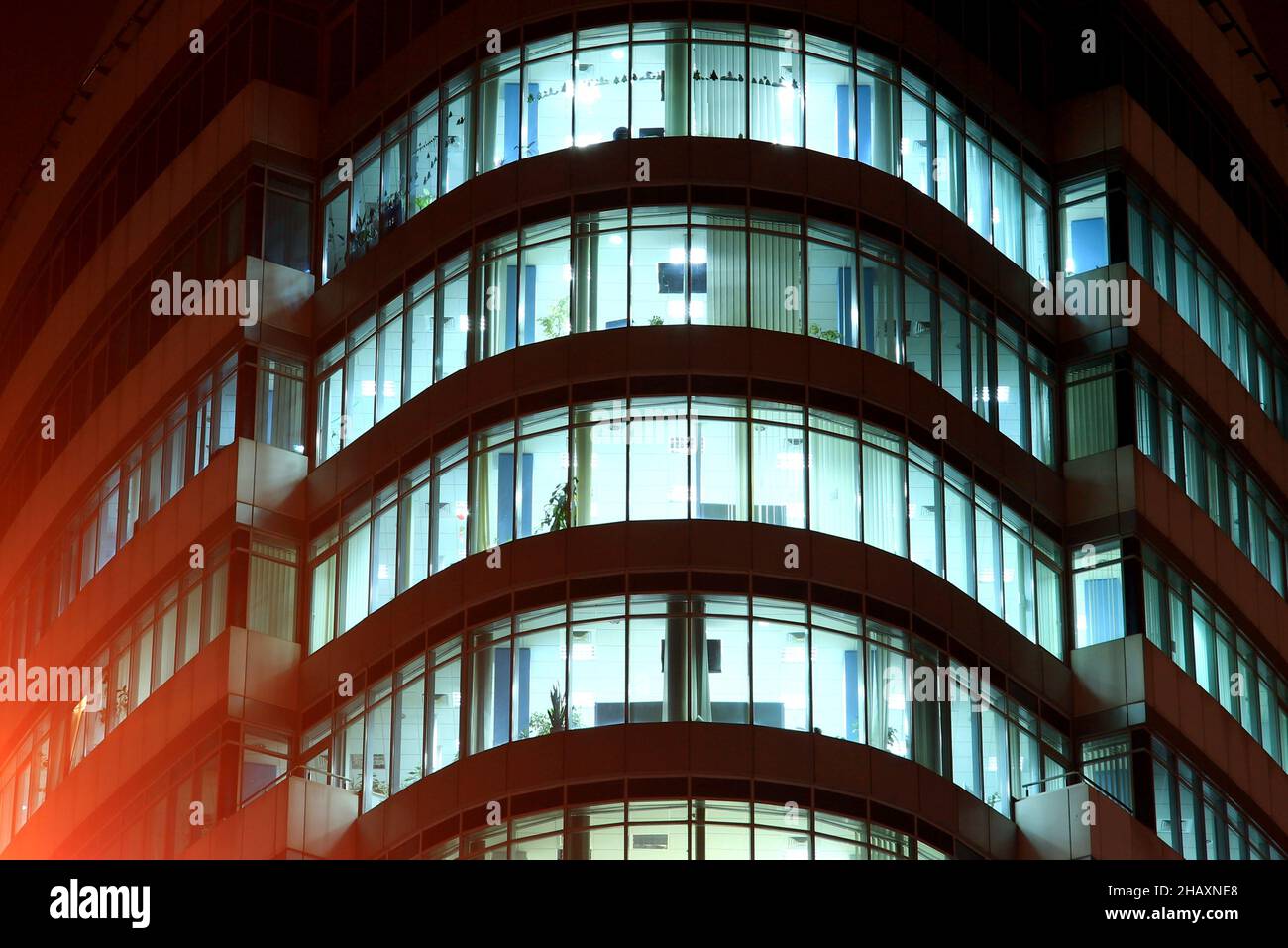 La façade d'un bâtiment en verre rond avec de grandes fenêtres panoramiques et des balcons la nuit, les fenêtres brillent dans l'obscurité.Dnipro City, Dnepr, Ukraine Banque D'Images