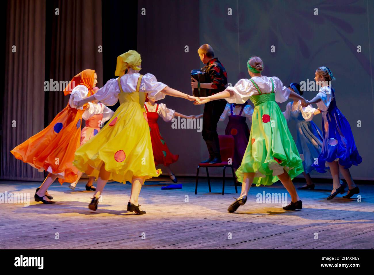 Omsk, Russie.05 décembre 2021.Les danseuses de Prohodka sont en train de courir autour du joueur de bayan.Performance de l'ensemble Samotsvety. Banque D'Images