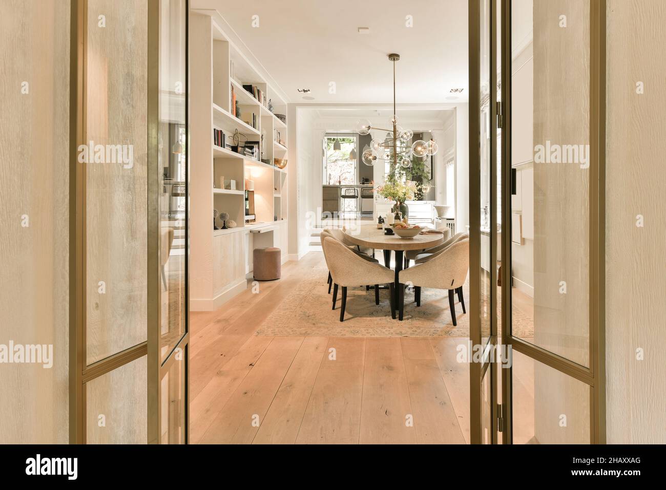 Intérieur d'un salon spacieux et contemporain avec table ovale entourée de fauteuils moelleux et de lustre suspendu et boîtier blanc avec Banque D'Images