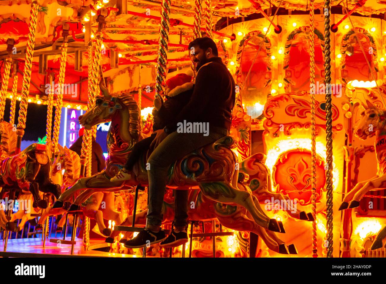 Bournemouth, Dorset, Royaume-Uni. 15 décembre 2021. Les visiteurs, les familles et les enfants enthousiastes affluent dans les jardins de Bournemouth par une douce soirée pour découvrir le pays des merveilles de l'arbre de Noël de Bournemouth avec plus de 100 arbres scintillants et illuminations. Certains des arbres sont thématiques pour représenter six villes à travers le monde. Les visiteurs peuvent suivre le sentier. Carrousel de chevaux au galop, joyeuse ronde à Pier Approach. Crédit : Carolyn Jenkins/Alamy Live News Banque D'Images