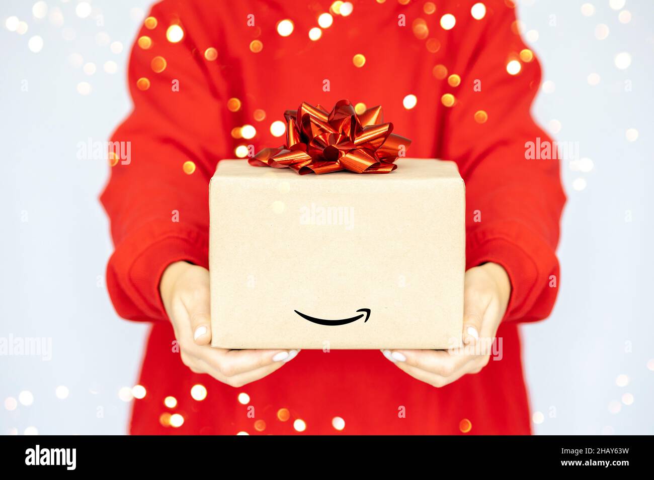 Livraison express Amazon.Une jeune femme dans un sweat-shirt rouge tient  une boîte en carton avec un noeud rouge.Vente d'achats en ligne Photo Stock  - Alamy