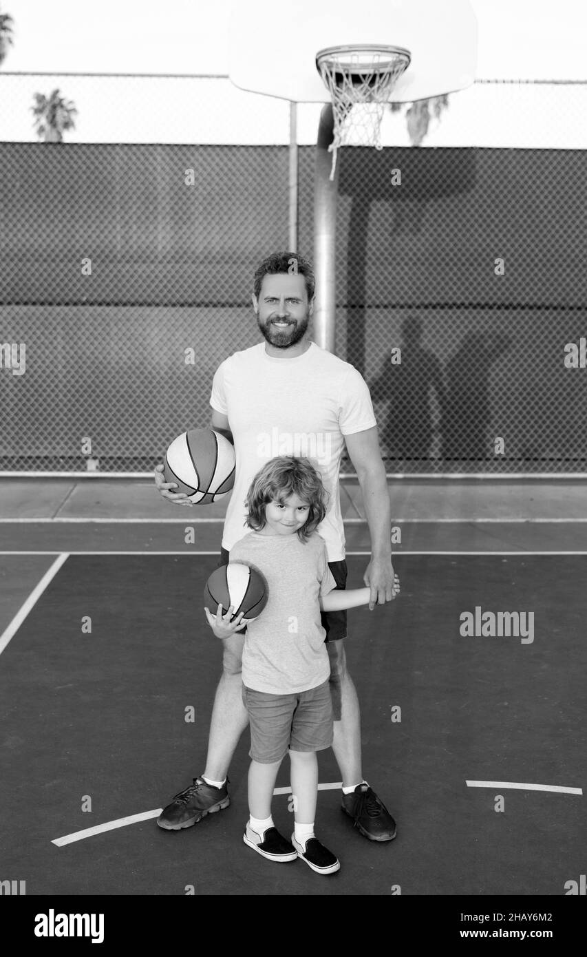 un père et un fils heureux jouent au basket-ball avec un ballon sur l'aire de jeux, pour une journée en famille Banque D'Images