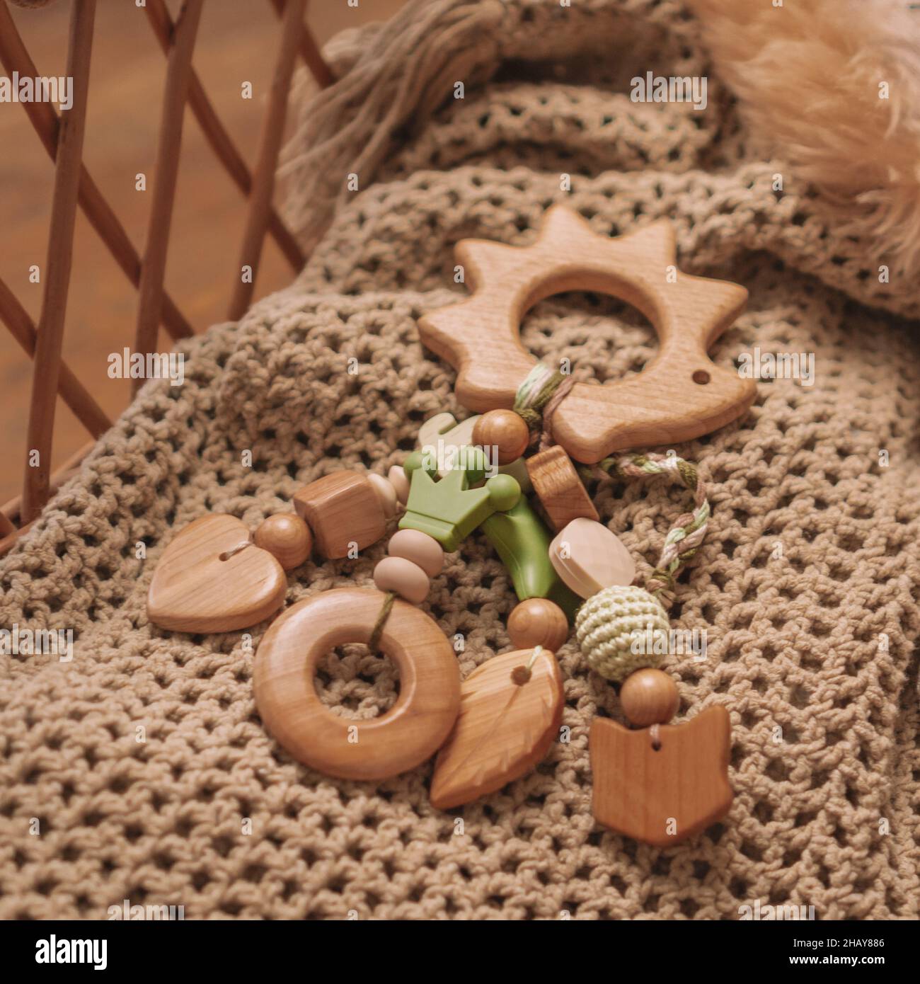 L'anneau de dentition en bois pour enfants en forme de hérisson avec perles de silicone repose sur une couverture beige dans un panier avec un jouet doux.Utilisation d'instagram à cadre carré Banque D'Images