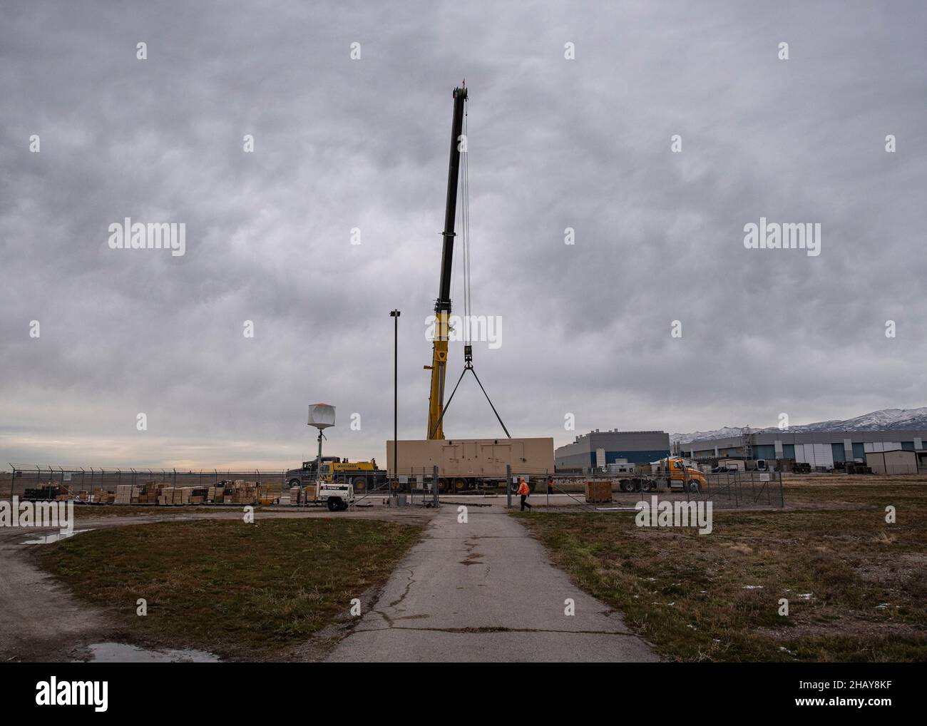 Une compagnie de grue sous contrat lève de nouvelles installations de stockage en place le 13 décembre 2021 à la base de la Garde nationale aérienne Roland R. Wright, Utah.Les installations délabrées, qui avaient plus de 20 ans, étaient remplacées le même jour par des bâtiments neufs et améliorés.(É.-U.Photo de la Garde nationale aérienne par le Sgt.John Winn) Banque D'Images