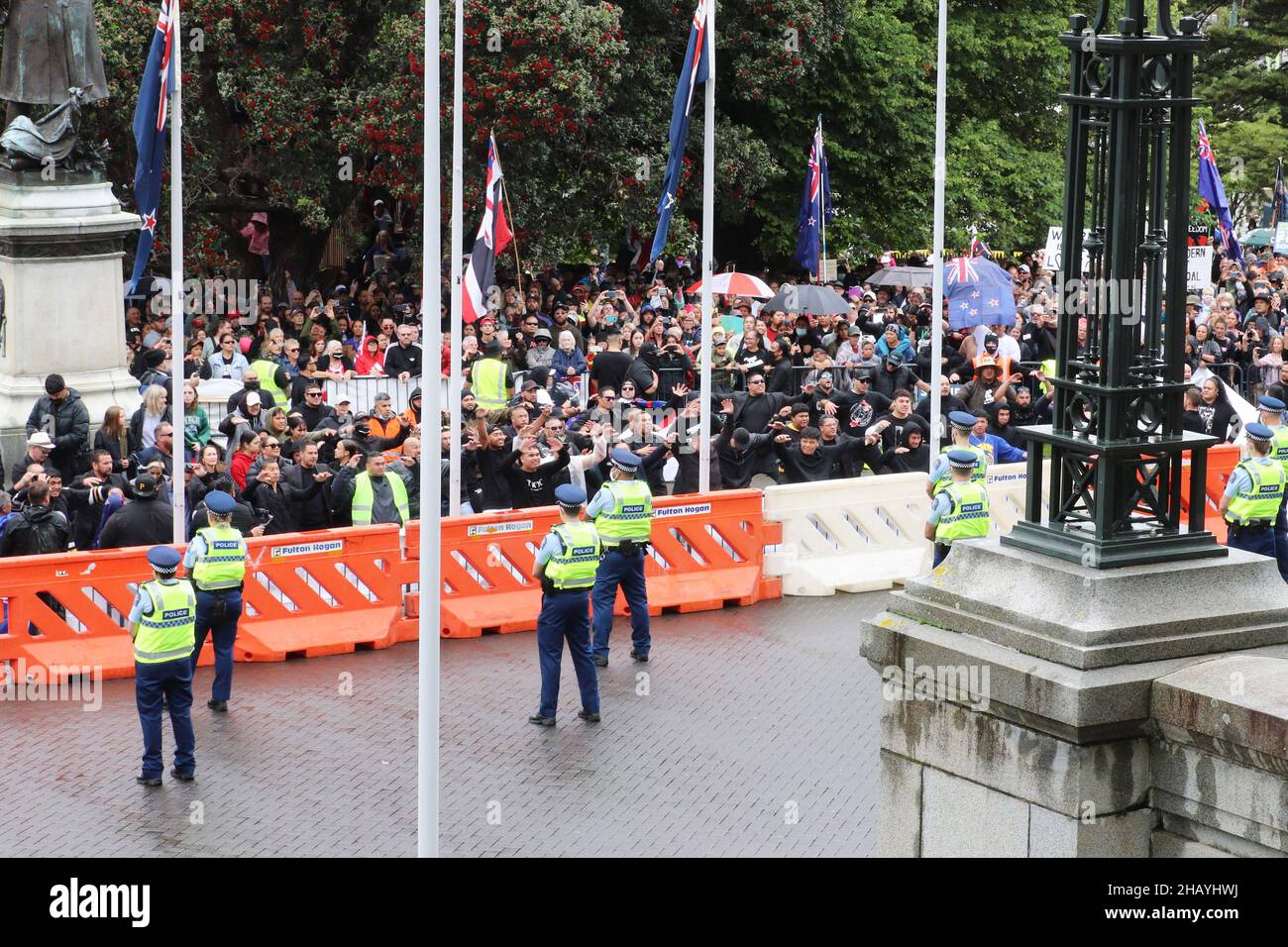 Wellington, Nouvelle-Zélande.16 décembre 2021 : les policiers qui surveillent l'entrée du Parlement néo-zélandais observent les jeunes Maoris qui effectuent un haka lors d'une manifestation contre les mandats d'emploi du vaccin Covid-19 et les restrictions imposées aux personnes non vaccinées qui entrent dans les bars, les restaurants et certains autres lieux.Les taux de vaccination sont plus faibles et les infections à Covid sont plus élevées chez les Maoris et les Pacific Islanders que dans la population générale.Crédit : Lynn grief/Alamy Live News Banque D'Images