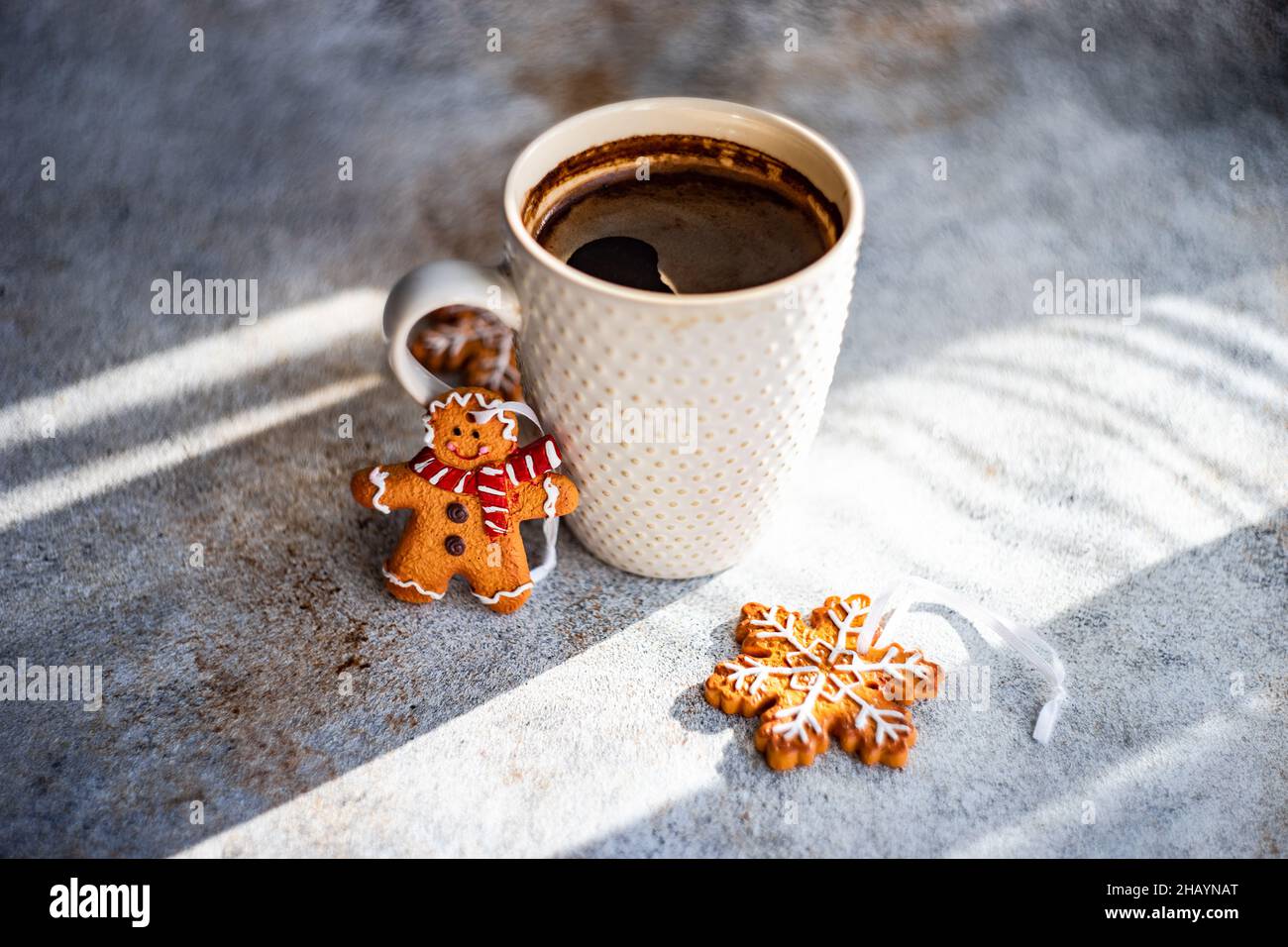 Tasse de café noir, flocons de neige et pain d'épice biscuits de Noël hommes sur une table Banque D'Images