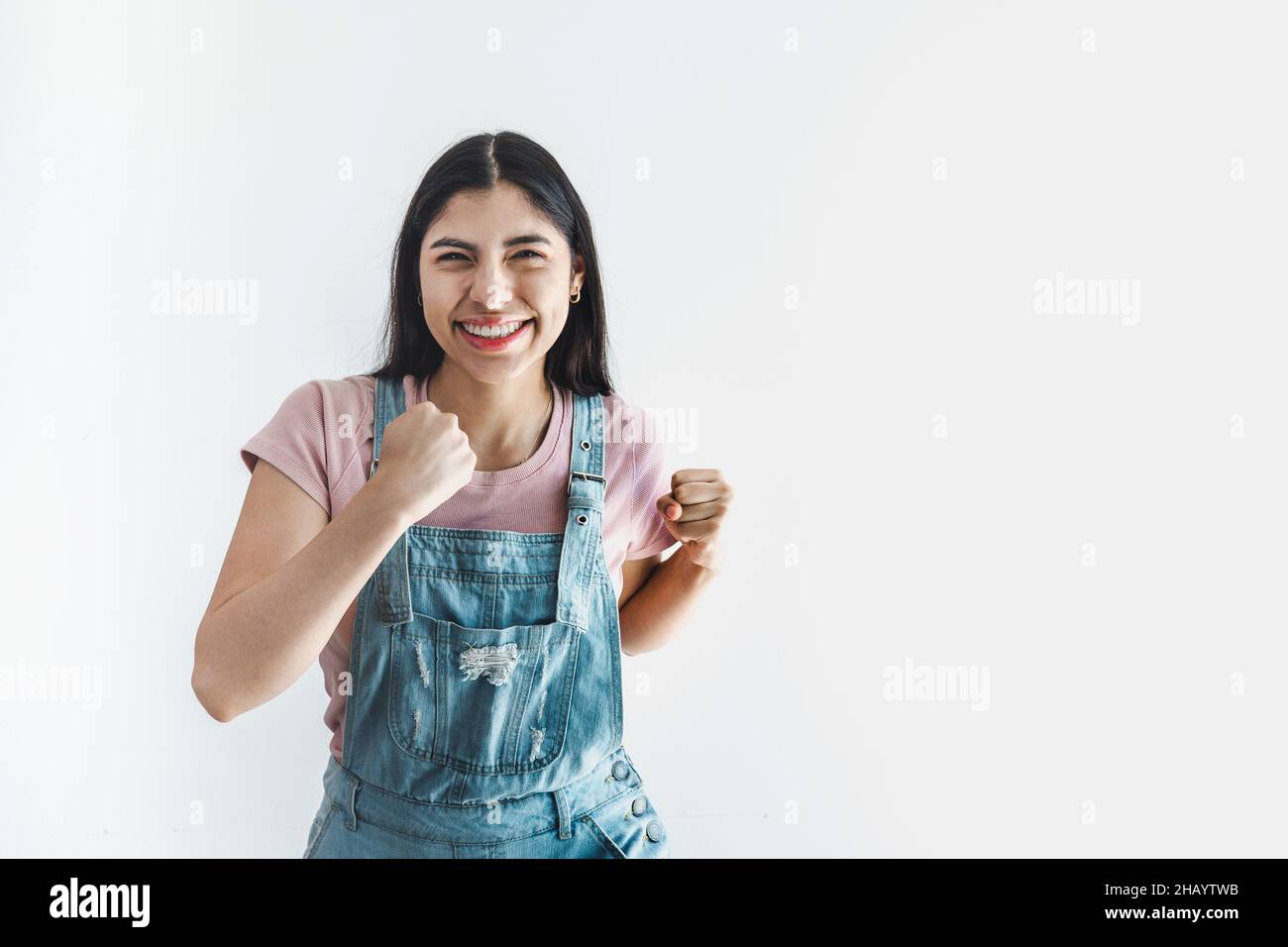 Jeune femme latine à expression positive face sur fond blanc en Amérique latine Banque D'Images