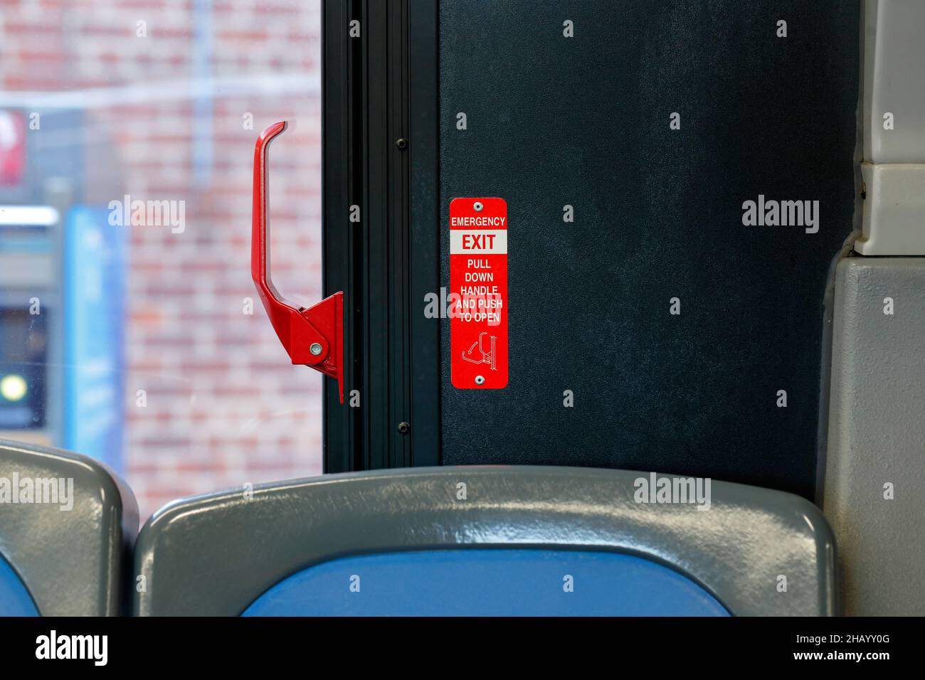 Une poignée de déverrouillage d'urgence rouge sur un bus; elle ouvre une fenêtre pour servir de sortie de secours. Banque D'Images