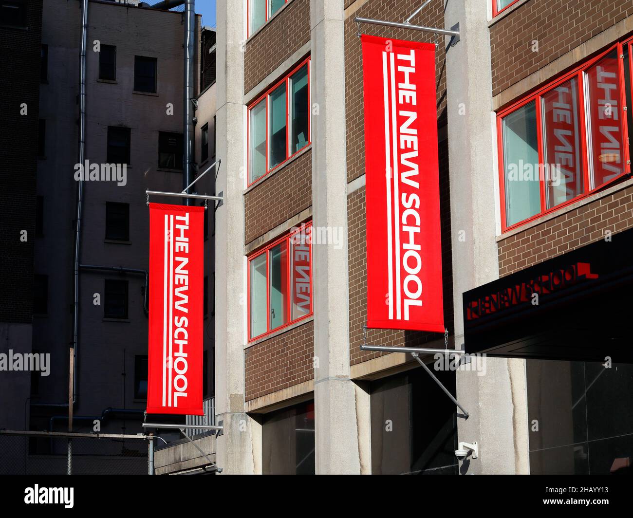 Les drapeaux verticaux de la New School pendent un dortoir éclairé par le soleil à New York, NY. Banque D'Images