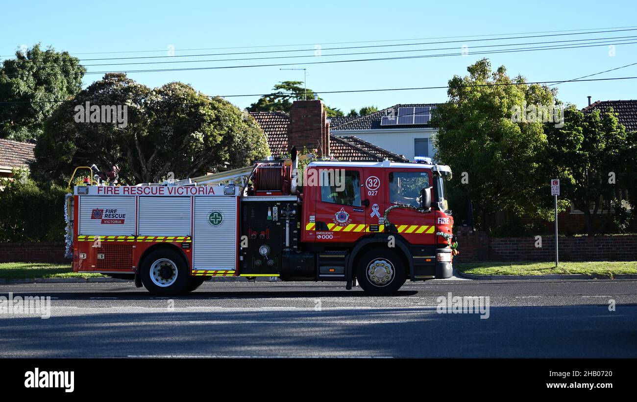 Sauvetage d'incendie camion de feu de Victoria se dirigeant vers l'ouest le long de North Rd, avec des sirènes de torchage, tandis que recouvert de décorations de Noël Banque D'Images