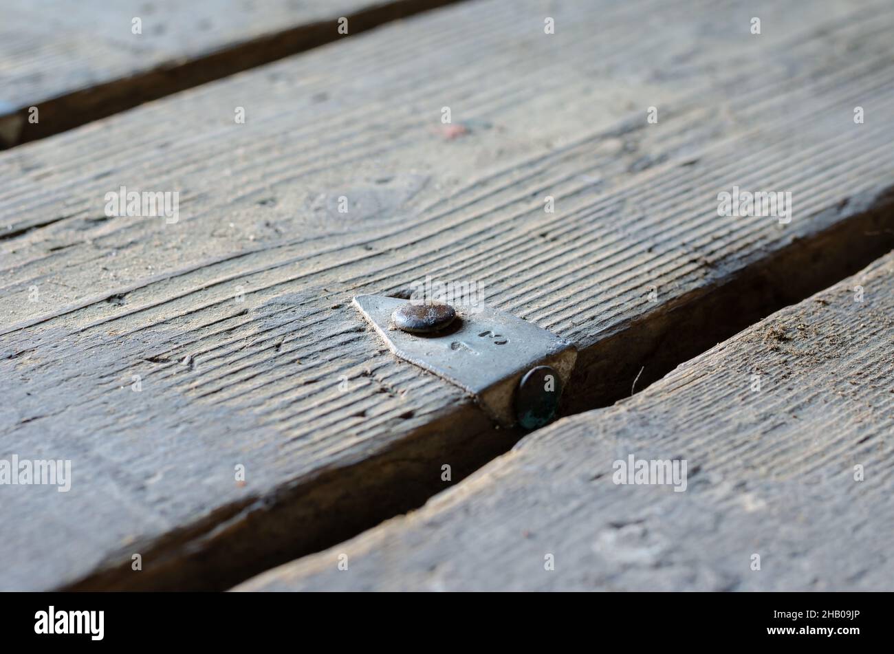 Numéro 13.Une ancienne carte avec une étiquette en aluminium.Barre métallique clouée au plancher.Gros plan.Mise au point sélective. Banque D'Images